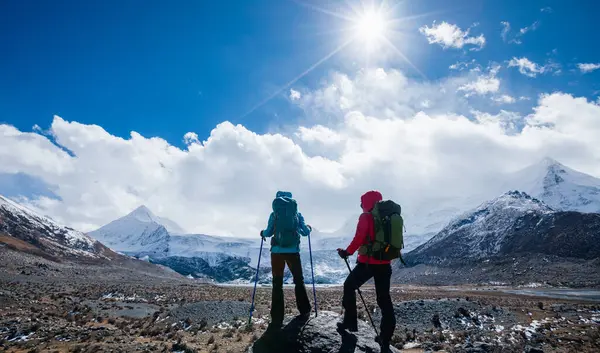 標高の高い冬の山々をハイキングする2人のバックパッカー — ストック写真