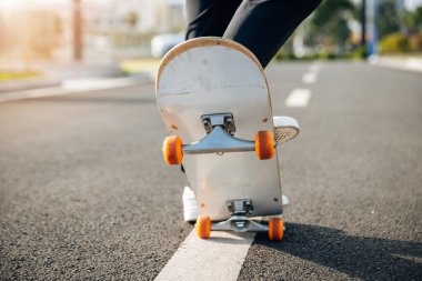 Kaykaycı şehir dışında kaykay yapıyor.