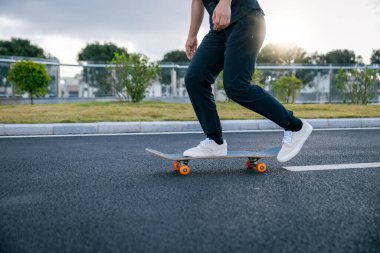 Kaykaycı şehir dışında kaykay yapıyor.