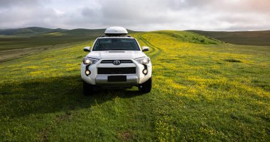 Tibet, Çin - 13 Haziran 2023, Toyota 'yı yüksek rakımlı çayır dağlarında yoldan çıkarmak