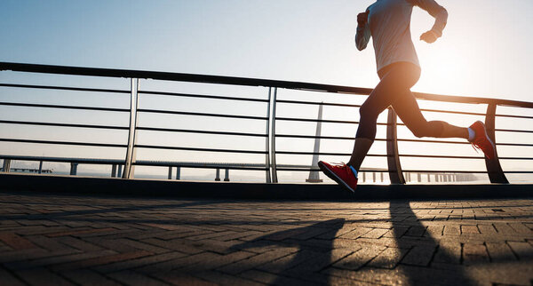 Fitness woman runner running at seaside 