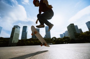 Modern şehirde Asyalı kaykaycı kadın.