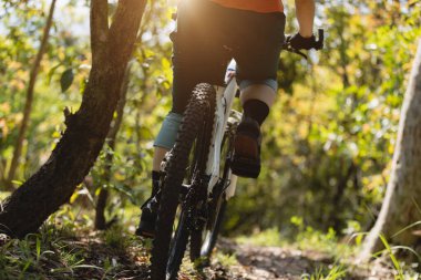 Kadın dağ bisikleti bahar ormanı patikasında