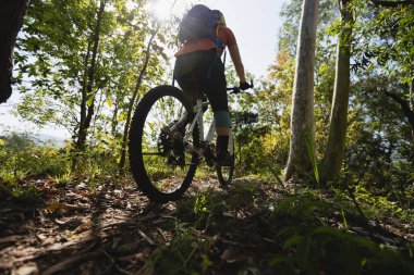 Kadın dağ bisikleti bahar ormanı patikasında