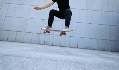 Modern şehirde Asyalı kaykaycı kadın.