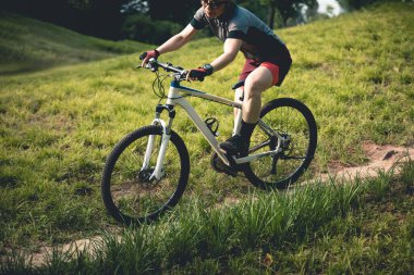 Gündüz vakti dağ yolunda bisiklet süren bir kadın 