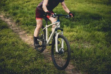 Dağ yolunda bisiklet süren kadın.