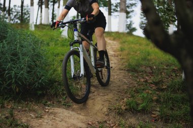 Dağ yolunda bisiklet süren genç bir kadın. 