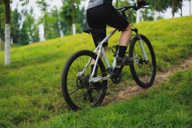 Dağ yolunda bisiklet süren kadın.