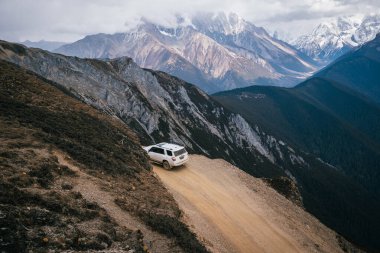 TIBET, ÇİN - 19 Mart 2022: Tibet, Çin 'deki yüksek irtifa dağlarında off-road araba sürmek