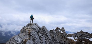 Tibet 'te dağın tepesinde yürüyüş yapan bir kadın.