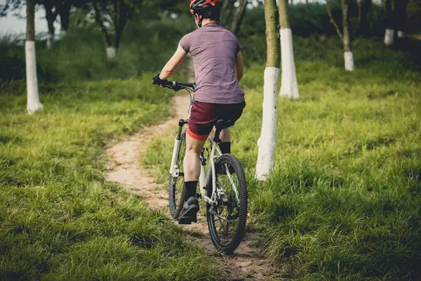 Dağ yolunda bisiklet süren kadın.