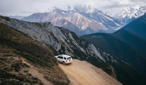 TIBET, ÇİN - 19 Mart 2022: Tibet, Çin 'deki yüksek irtifa dağlarında off-road araba sürmek