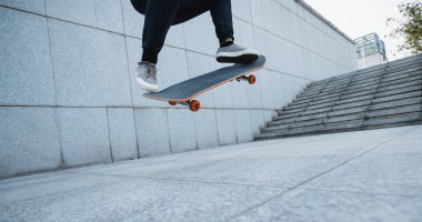 Kentteki kaykay parkında kaykay yapan kadın kaykaycı.