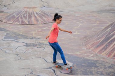 Şehirdeki kaykay parkında genç bir kadın.