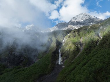 Çok güzel yüksek irtifa manzarası. Karla kaplı dağ ve şelale manzarası.