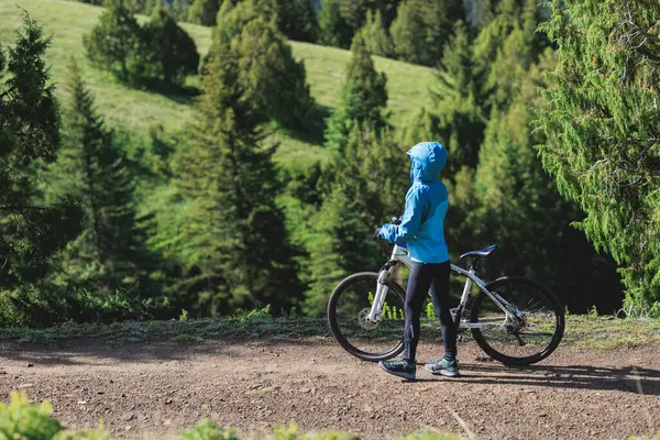 Stock image Woman riding mountain bike in forest mountain