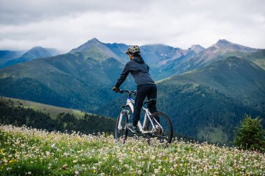 Otlağın tepesinde dağ bisikleti sürüyorum