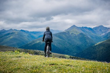 Otlağın tepesinde dağ bisikleti sürüyorum