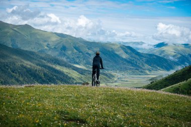 Otlağın tepesinde dağ bisikleti sürüyorum