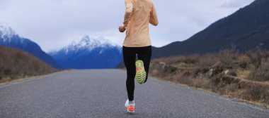 Baharda Tibet 'te koşan kadın, uzaktaki karlı dağlarla