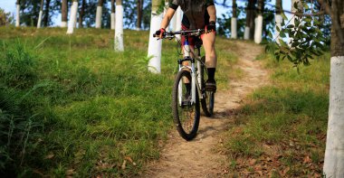 Dağ yolunda bisiklet süren bir kadın.