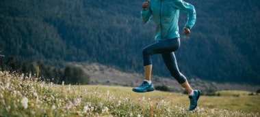 Ormanda ve çayırlarda koşan ultra maraton koşucusu kadın.