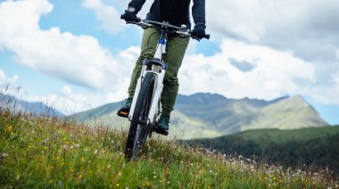 Riding mountain bike in the flowering beautiful mountain top clipart