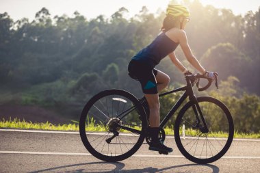 Yaz parkında bisiklet süren bir kadın.