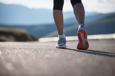 Fitness kadın koşucusu Sunset Mountain Top Road 'da koşuyor.