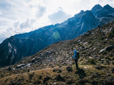 Yükseklik dağlarında yürüyüş yapan bir kadın.