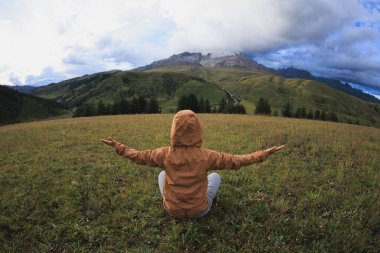 Yüksek rakımlı dağın tepesindeki çayırlarda kadın yürüyüşçülerin meditasyonu