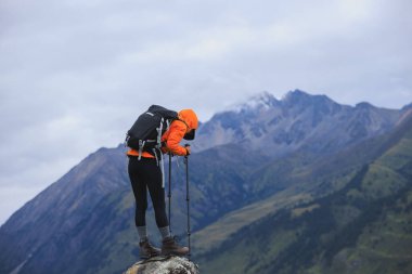 Sırt çantalı bir kadın yüksek irtifada dağ yürüyüşü yapıyor.