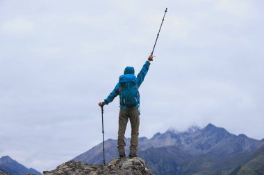 Sırt çantalı bir kadın yüksek irtifada dağ yürüyüşü yapıyor.