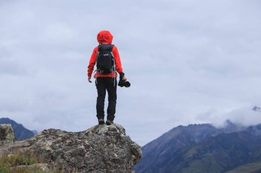 Dağın tepesinde kameralı başarılı bir yürüyüşçü.