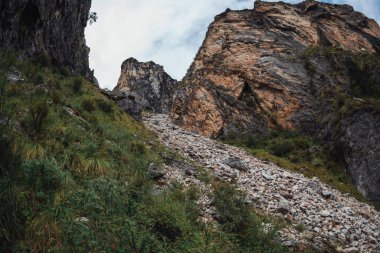 Yüksek bir dağ manzarasına uzanan dik kayalıklar