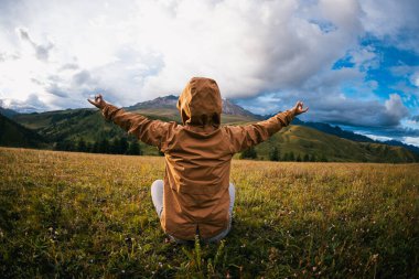 Yüksek rakımlı dağın tepesindeki çayırlarda kadın yürüyüşçülerin meditasyonu