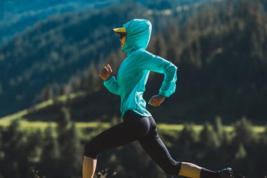 Fitness Asyalı kadın koşucu gün doğumunda otlakta koşuyor