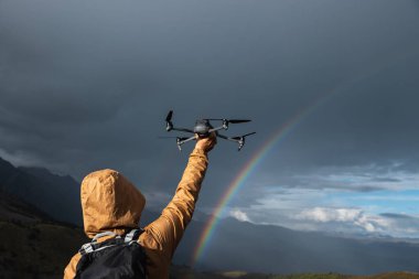 Fotoğrafçı gökkuşağının resmini çekiyor yüksek irtifada çayırların tepesinde bir dron ile.