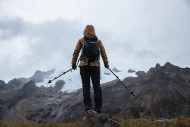 Sırt çantalı bir kadın yüksek irtifada dağ yürüyüşü yapıyor. 