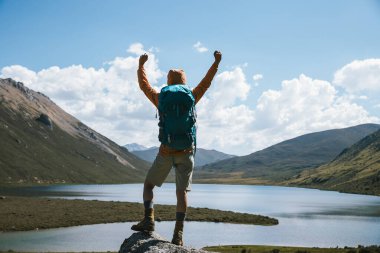 Sırt çantalı bir kadın yüksek irtifada dağ yürüyüşü yapıyor.