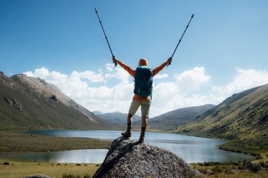 Sırt çantalı bir kadın yüksek irtifada dağ yürüyüşü yapıyor.