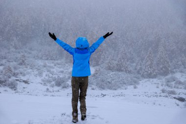 Kadın güzel kar manzarasının tadını çıkarıyor.