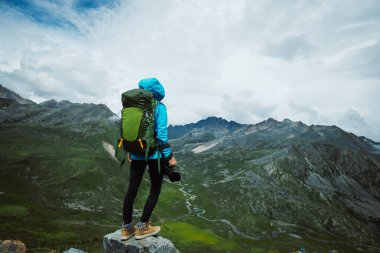 Kışın hugh buzulu dağında yürüyüş yapan kadın yürüyüşçü, Çin