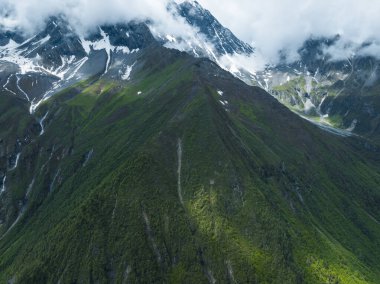 Çok güzel yüksek irtifa manzarası. Karla kaplı dağ ve şelale manzarası.