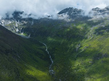 Çok güzel yüksek irtifa manzarası. Karla kaplı dağ ve şelale manzarası.