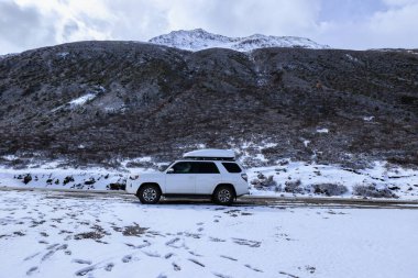 Driving car on high altitude mountain trail, China clipart