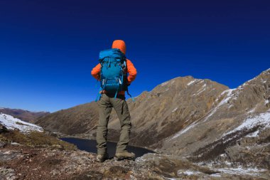 Sırt çantalı kadın yüksek irtifada dağın tepesinde