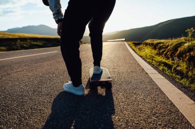 Kaykaycı, Sunset Dağı tepesindeki yolda kaykay yapıyor.