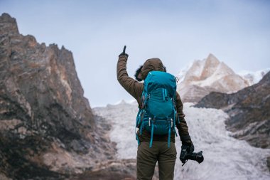 Yürüyüş yapan fotoğrafçı kadın yüksek rakımlı dağlarda asılı duran büyük buzulla şok oldu.